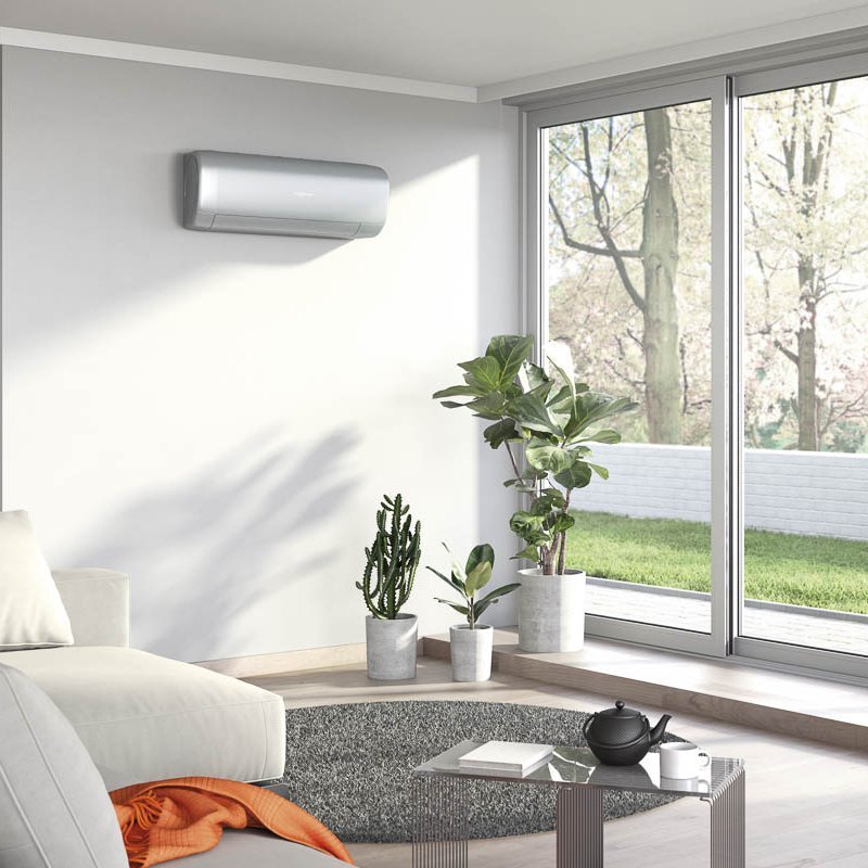 Ein großes Wohnzimmer mit Terrassentüren und einer Klimaanlage an der Wand.